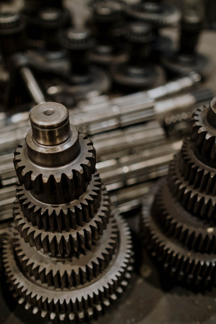 about-img Close-up view of stacked metal gears in a workshop, highlighting precision engineering.